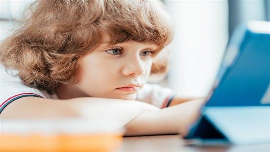 Bilde av et barn i 6-årsalderen som bruker smarttelefon.