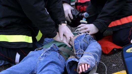 Ambulansearbeidere utfører hjertekompresjon på et barn