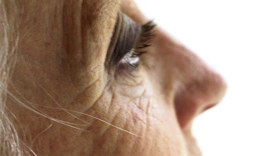 Illustrasjonsfotoet viser en eldre kvinne i profil. Nærbilde av øyeregionen