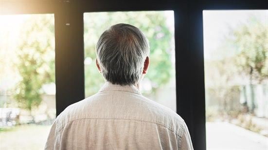 Illustrasjonsfotoet viser en man som ses bakfra og som ser ut av vinduer