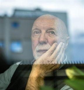 Illustrasjonsfoto av tankefull eldre mann som ser gjennom et vindu
